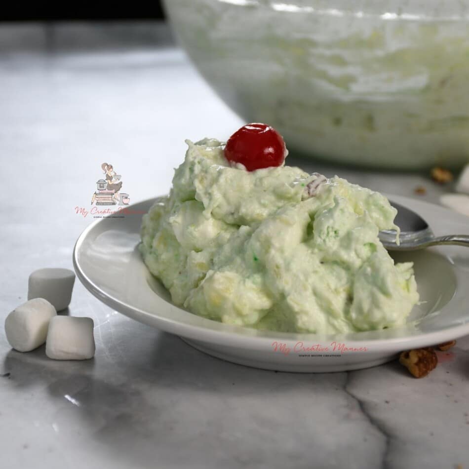 Watergate Salad on a plate with a cherry on top of it.