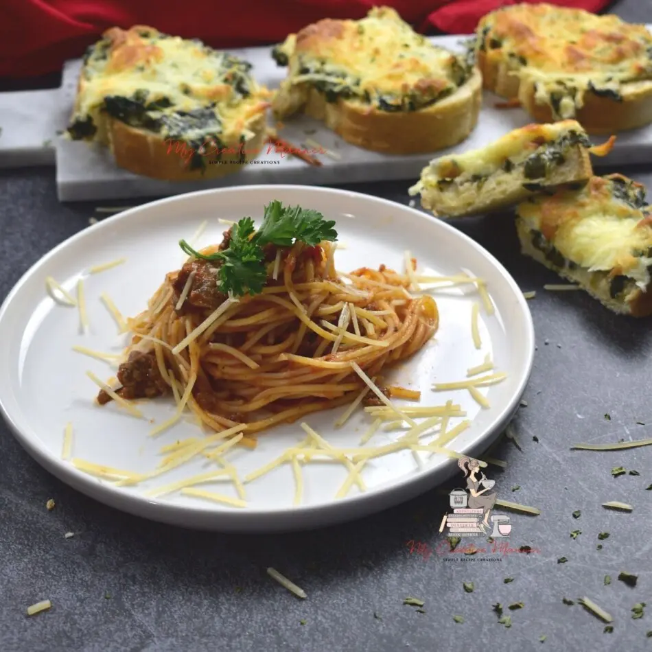 Spaghetti with meat sauce on a white plate with cheese toast on a platter behind it.