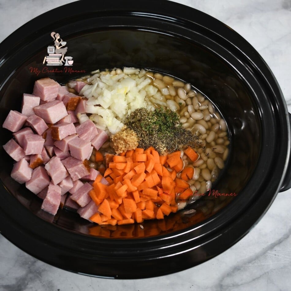 Beans, carrots, ham, onion, and spices in a crock pot.