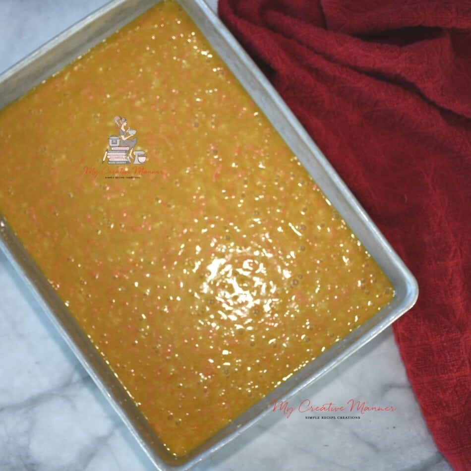 A baking pan with raw carrit cake batter in it. 