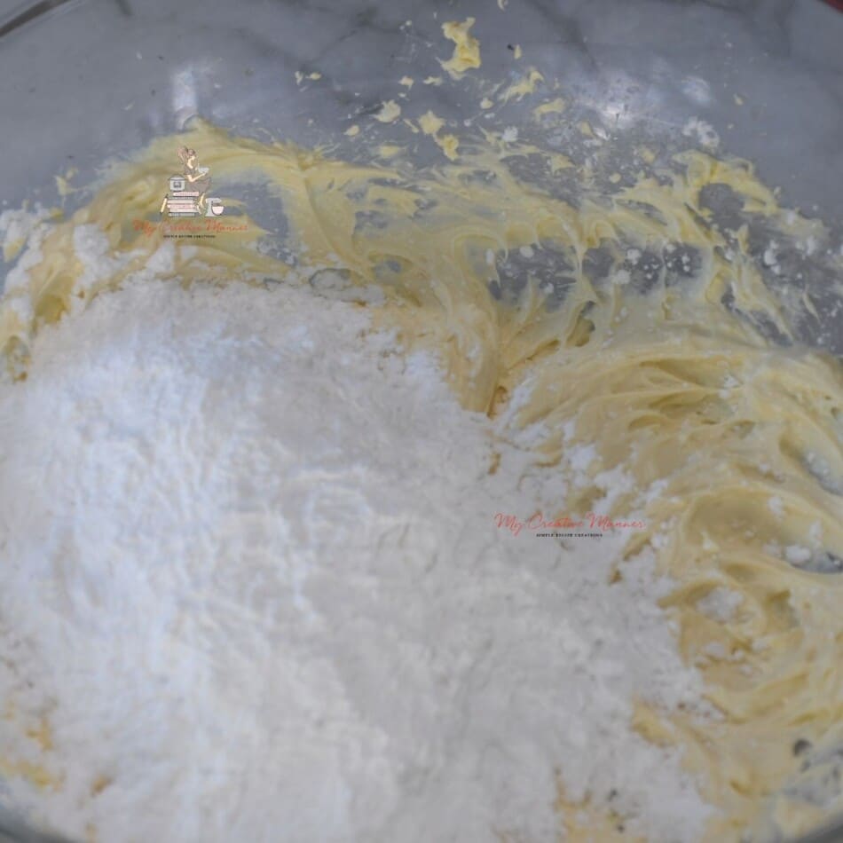 Powdered sugar being added into the butter mixture.