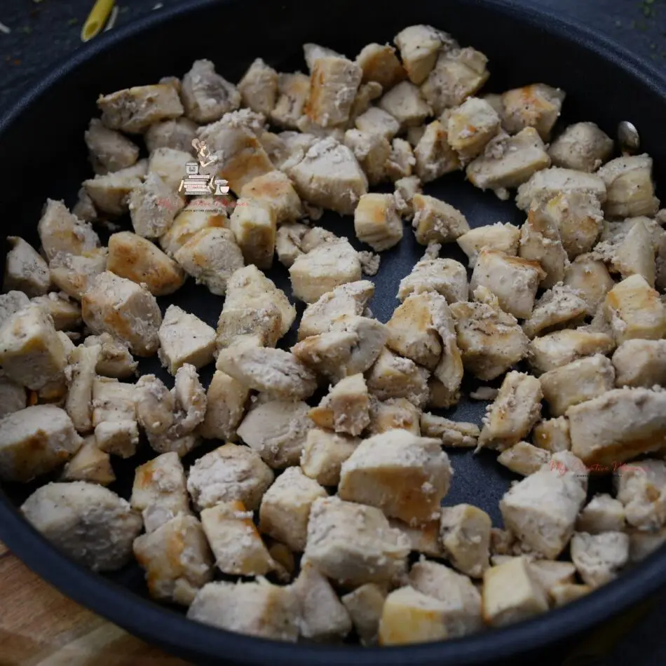 Chicken cubes in a skillet.