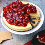 A whole cheesecake on a cake stand.