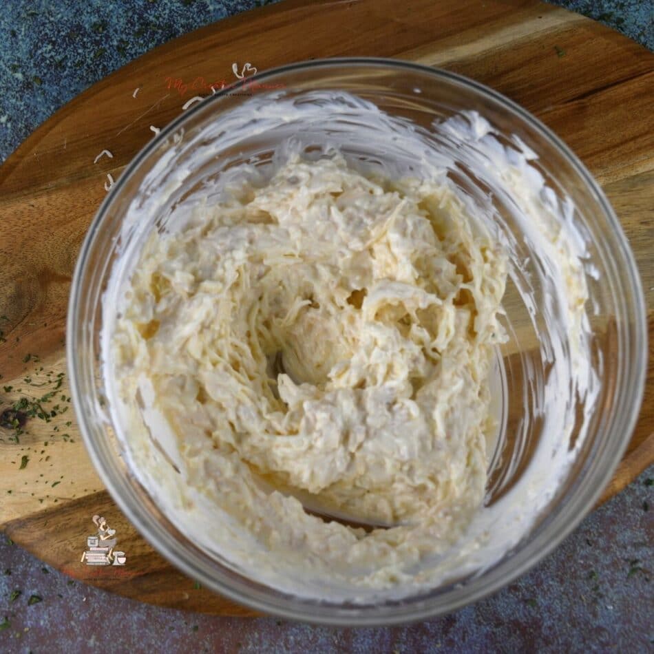 A creamy parmesan cheese and mayo dressing in a bowl that will go on chicken breast.