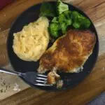 A complete dinner on a great plate with a fork on it.