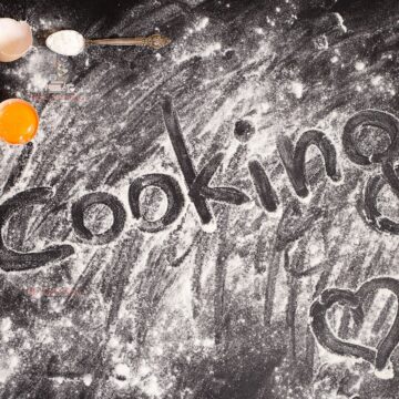 Flour in a black countertop with the words cooking on it.