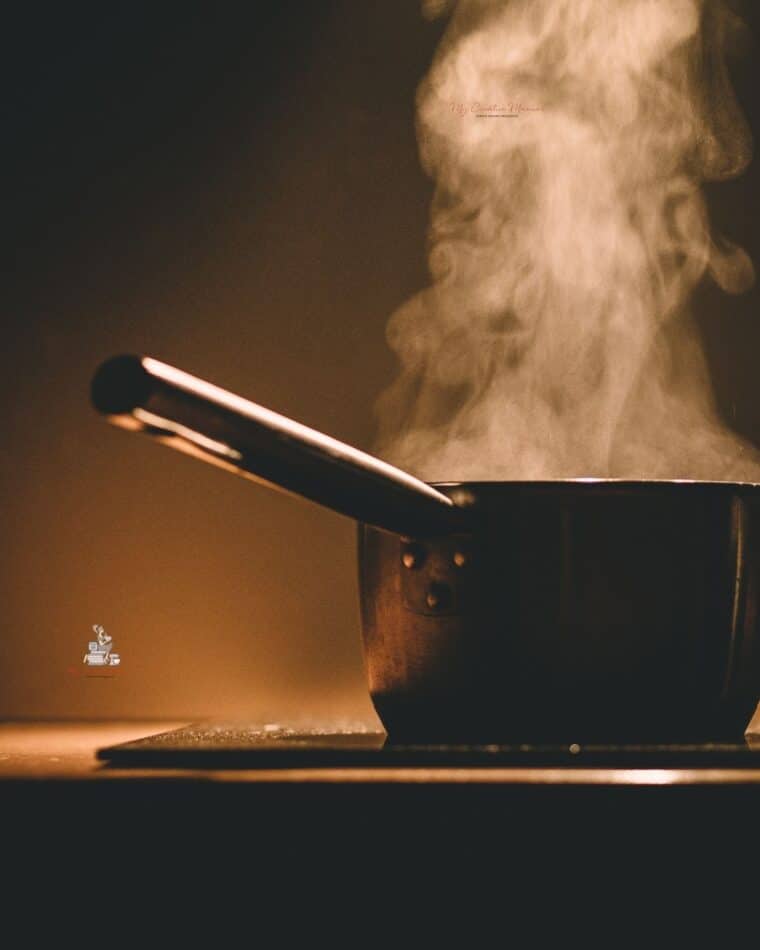 A pot on a stove with steam coming out.