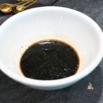 A white bowl with steak marinade in it that can be used for grilling.