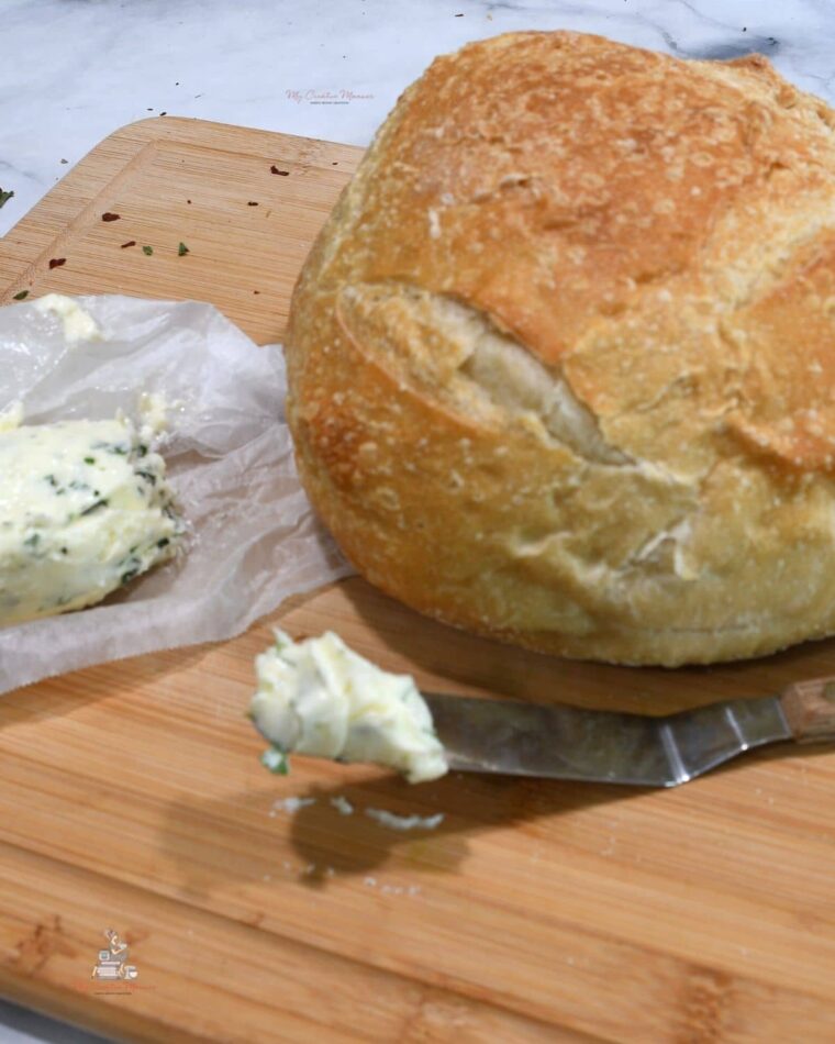 A sourdough bread and compound butter that is on a spatula and on parchment paper.