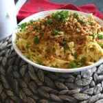 Butter noodles topped with ritz crackers in a white bowl that was inspired by Frankenmuth buttered noodles recipe.