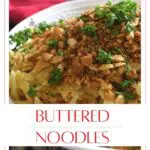 A bowl filled with buttered pasta with a crumb topping.
