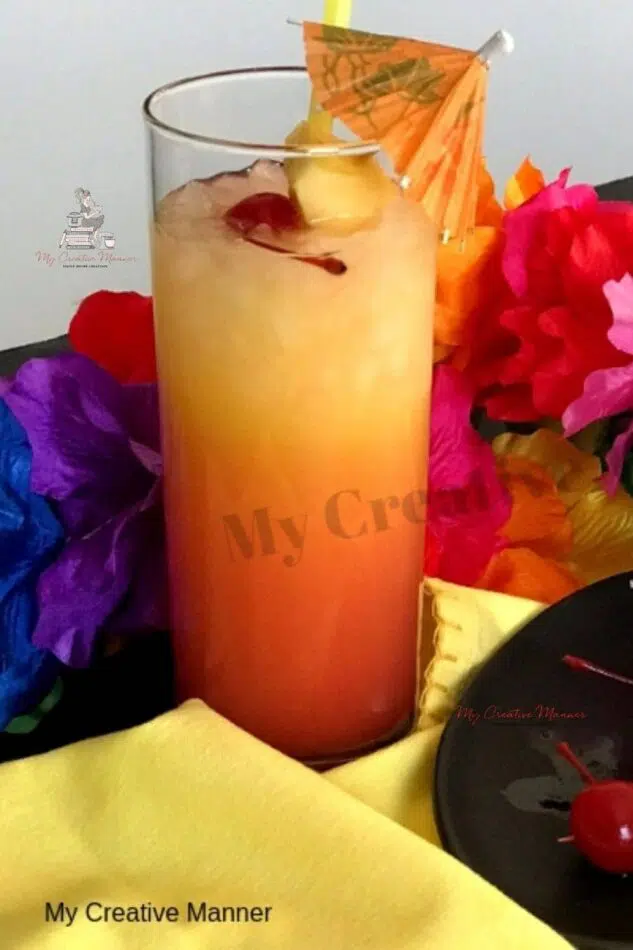 A tall glass that is filled with a Bahama Mama Drink and an umbrella.