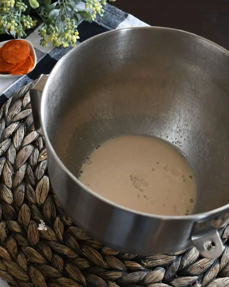 A mixing bowl with yeast that has bloomed. 