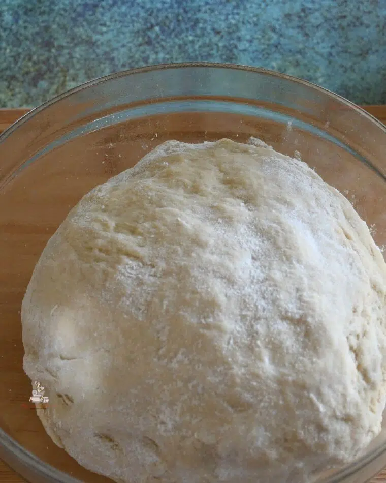 Homemade dough from scratch for yeast cinnamon rolls in a glass mixing bowl.