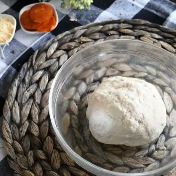 A bowl with homemade thin crust pizza dough in it.