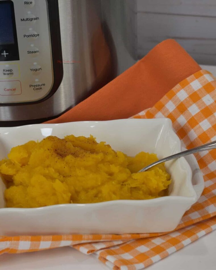 A whit edish with mashed acorn squash that has been cooked in the Instant Pot.