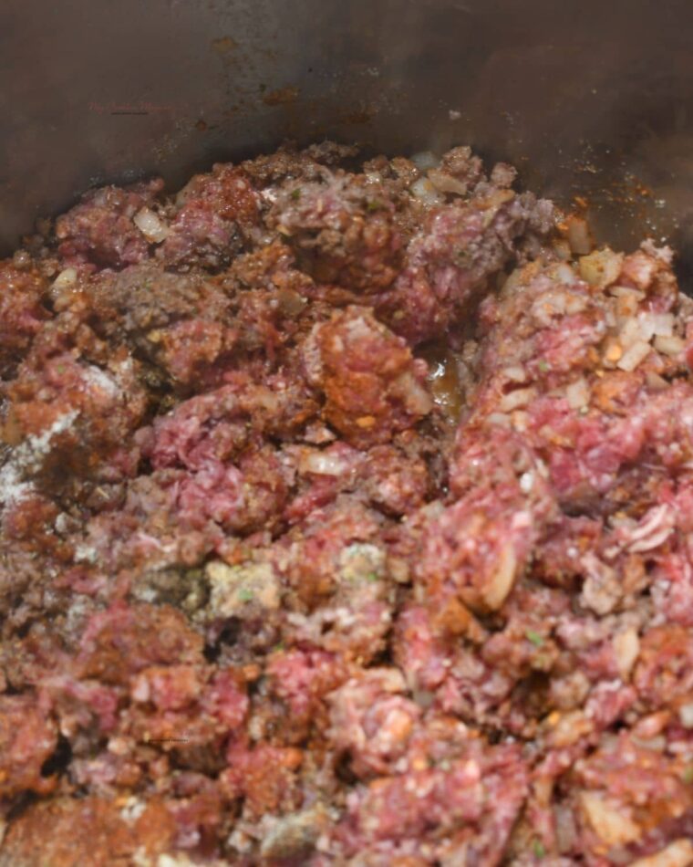 Raw ground beef being cooked in a Instant Pot.