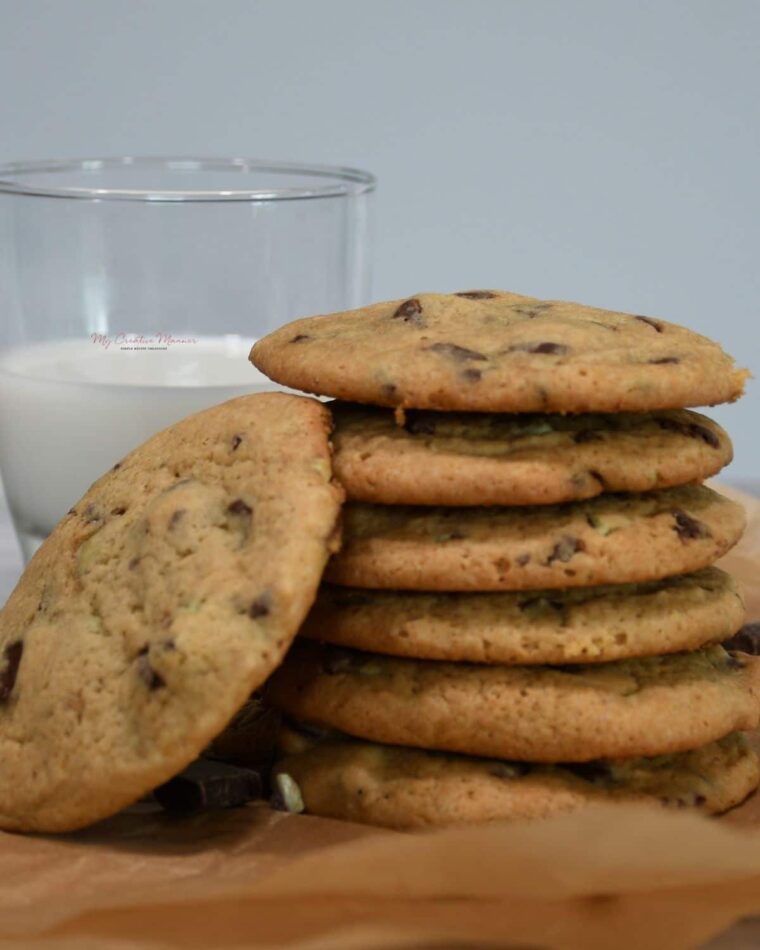 A stack of mint cookies with a glass of milk.