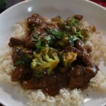 Classic beef with broccoli in a white bowl with rice.