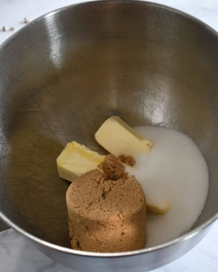 A mixing bowl with butter and sugars in it.