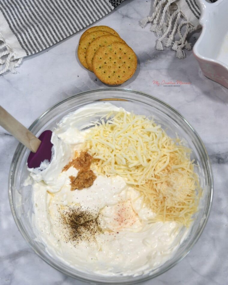The cream cheese and sour cream mixture with seasoning and cheese.