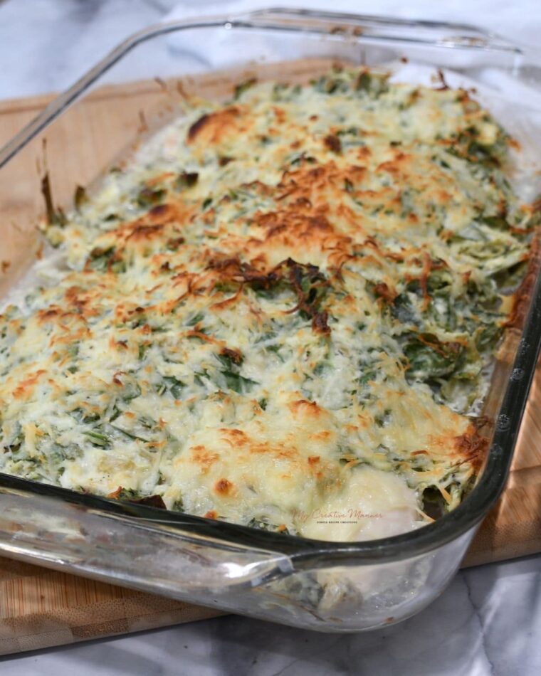 A baking dish with chicken spinach artichoke casserole in it. 