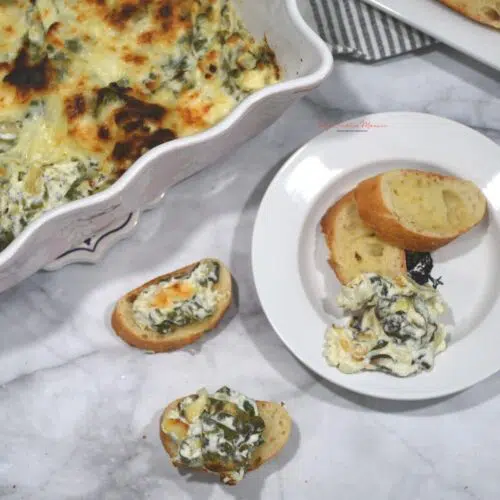 A dish with the spinach artichoke dip that has been baked.