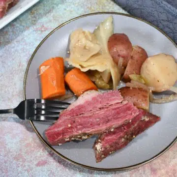 A plate full of slow cooker corned beef brisket and vegetables.