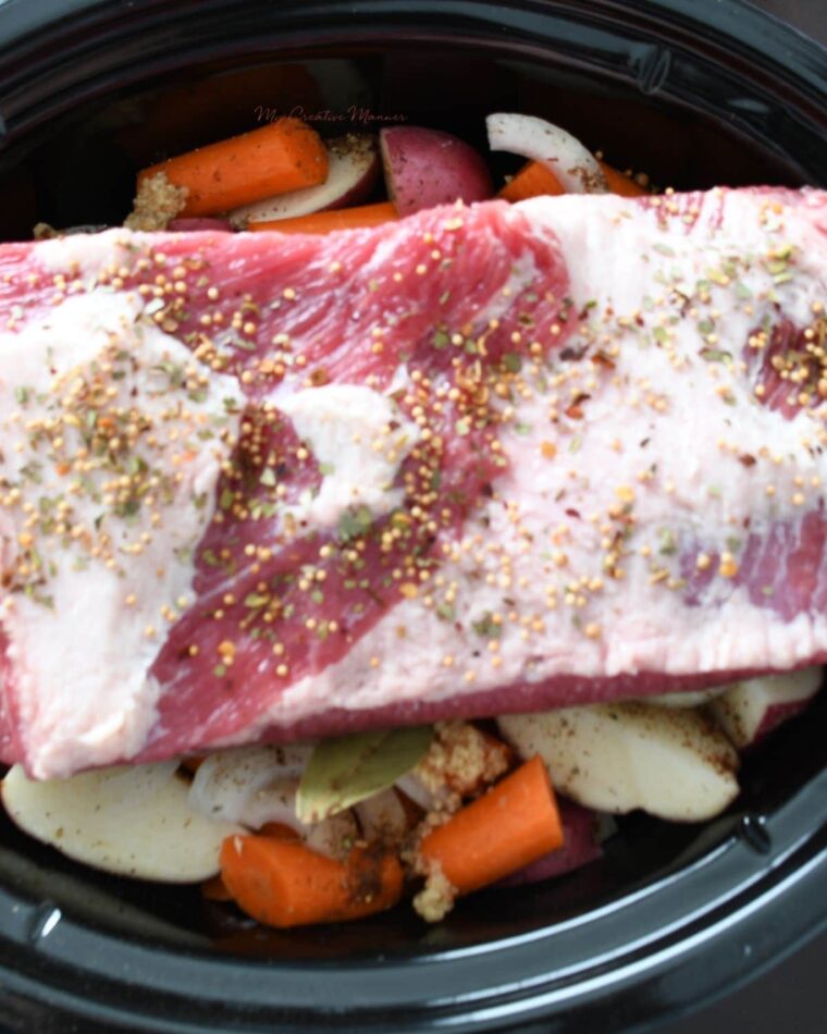 Corned beef brisket and vegetables in a crock pot with beer. 