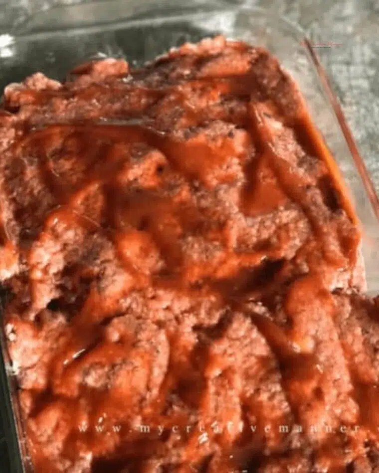 The best ever meatloaf recipe in a glass baking dish that hasn't been cooked yet.