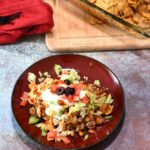 Overhead shot of a plate with walking taco casserole with fritos on it.