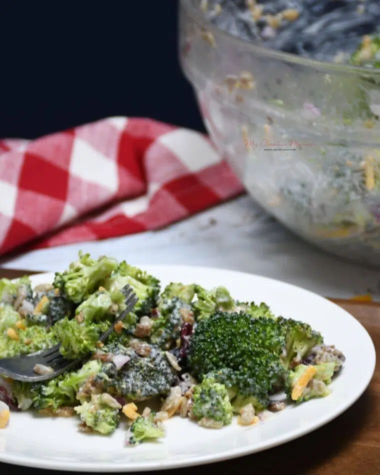 Broccoli summer salad on a plate with a fork.
