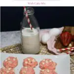 A platter with strawberry cookies with white chocolate chips that are made from a cake mix. A glass of milk sits next to the platter.