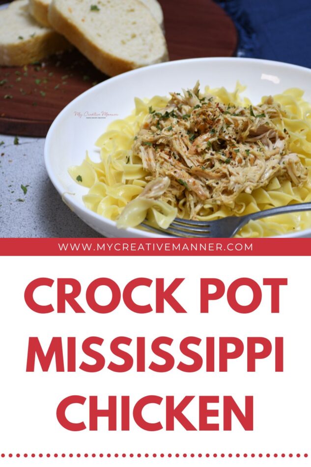 A bowl with egg noodles that are covered with crock pot Mississippi chicken with bread behind the bowl.