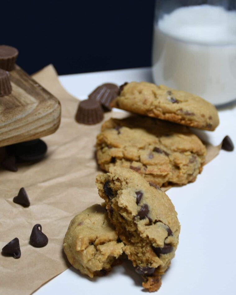 A close up of peanut butter cup cookies with Reese's that have been split in half.