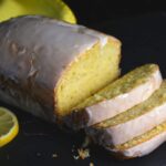 A loaf of lemon bread with a sweet lemon glaze that has been cut into slices.