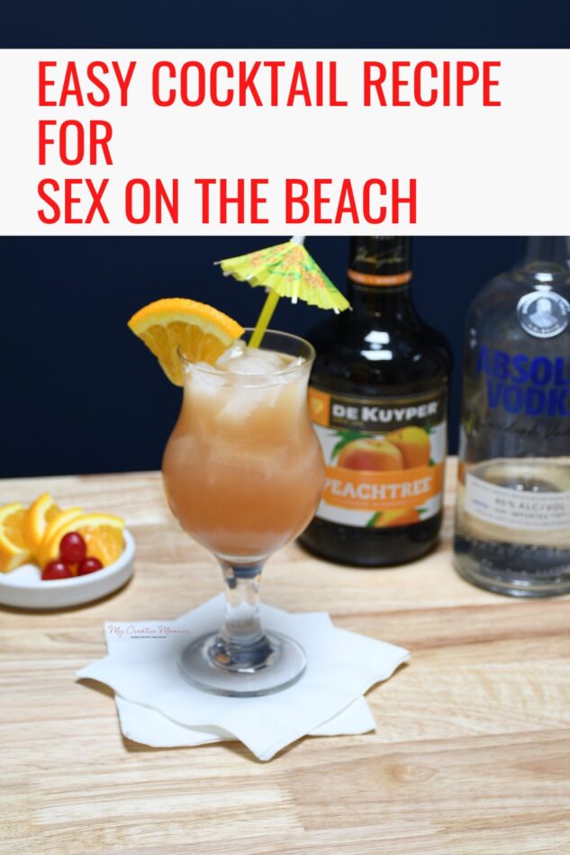 A bottle of vodka and peach schnapps is behind a hurricane glass that is filled with sex on the beach cocktail.