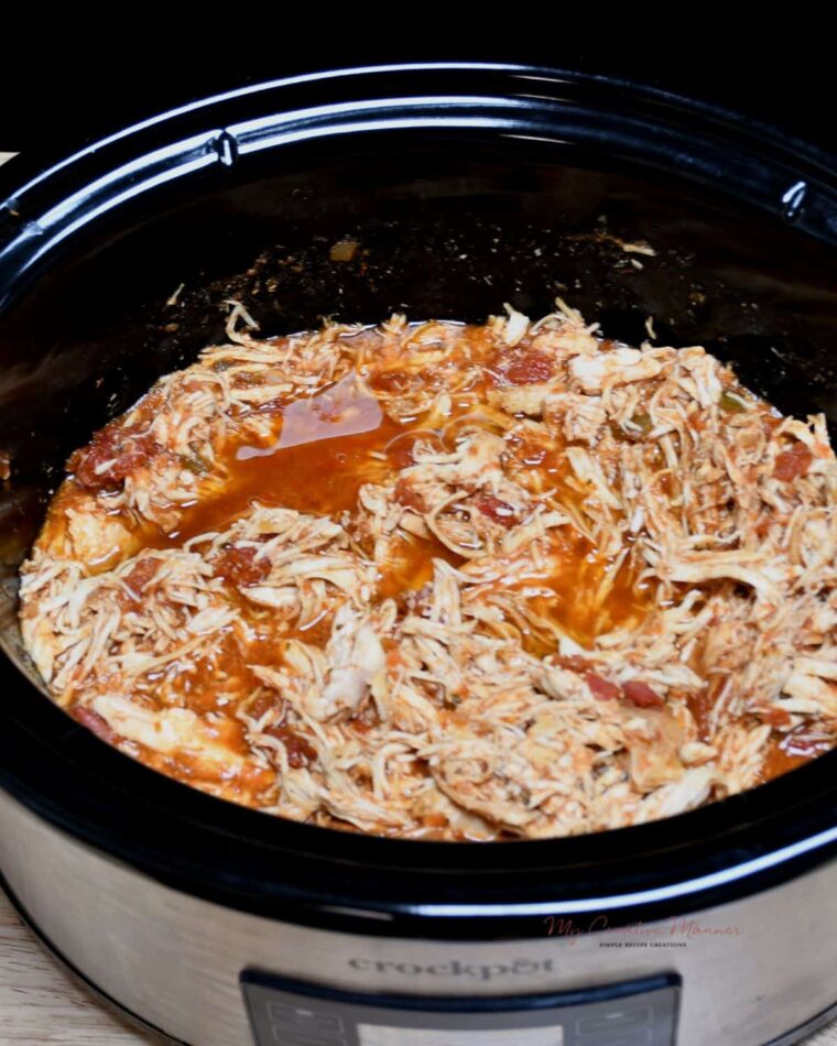 A crockpot filled with shredded chicken taco meat.