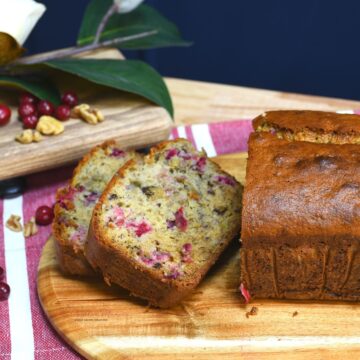 Easy cranberry banana bread on a wood board that has been sliced.