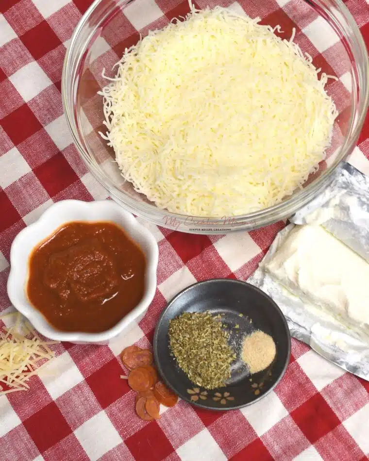 Overhead shot of the ingredients needed to make a simple pizza dip with pepperoni.