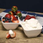 A dish with fruit fruit and a cream cheese fruit dip in it.
