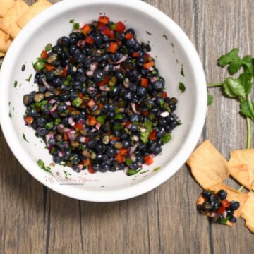 A bowl of blueberry salsa that is made with red pepper, jalapeno pepper, and fresh lemon juice.