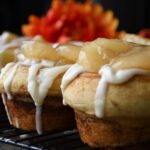 A close up of one apple pie cup that is made with refergrated cinnamon rolls.