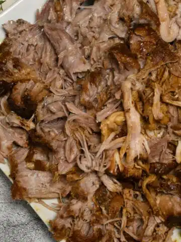 An overhead shot of a plate that is filled with bbq pulled pork that was made in the slow cooker.