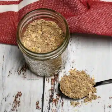 Overhead shot of a jar and a spoon that has onion soup mix on it.