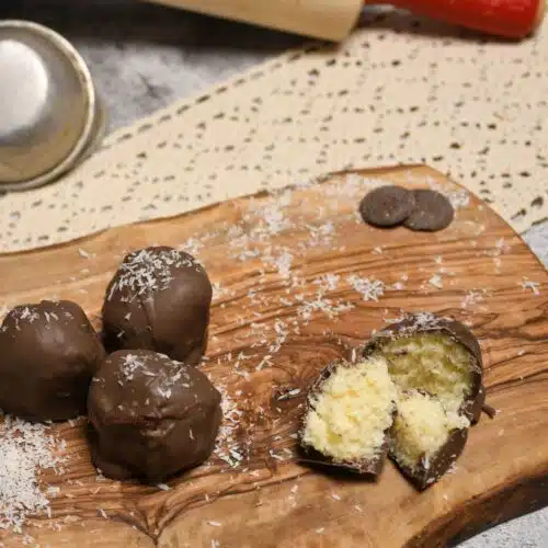 No bake three ingredient coconut balls on a wooden board.