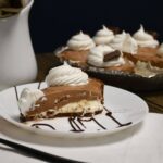 A plate that has a slice of chocolate pie on it.