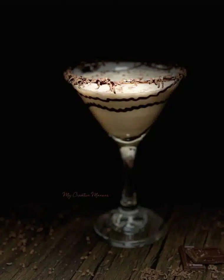 A single chocolate martini cocktail with chocolate shavings.