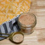 A tablespoon and jar filled with the homemade seasoning salt recipe.