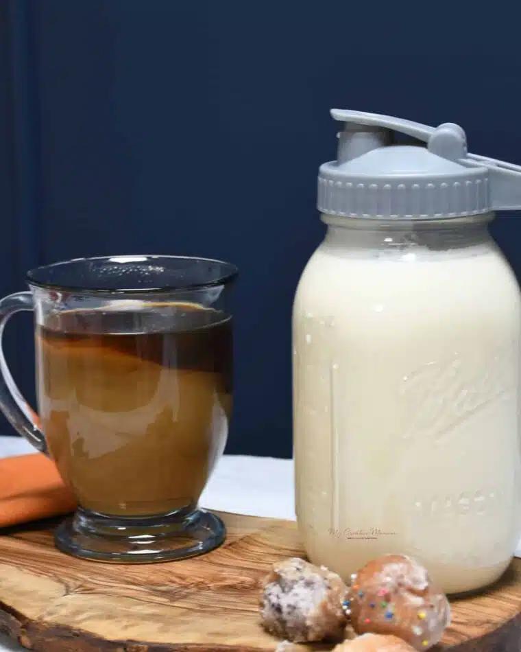 A jar with coffee creamer and a cup of coffee with some homemade creamer added in.